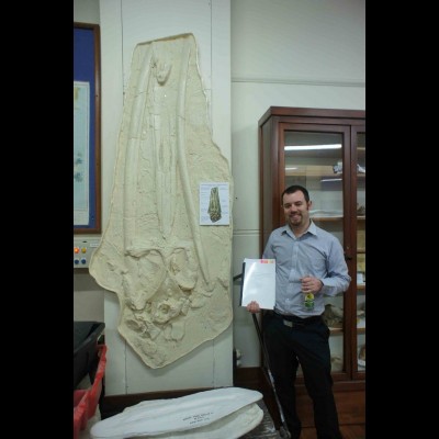 Bobby with a cast of Tokarahia kauaeroa (another eomysticetid he named)&nbsp;mounted on the wall at the University of Otago in New Zealand.&nbsp; That's his Ph.D. thesis in his hand, and a celebratory beer to commemorate it's completion.