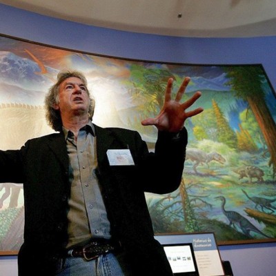 Artist William Stout discusses one of his murals during a &ldquo;Fossil Mysteries&rdquo; tour at the Natural History Museum in Balboa Park. (Photo courtesy of San Diego Tribune, photo by Sandy Huffaker)
