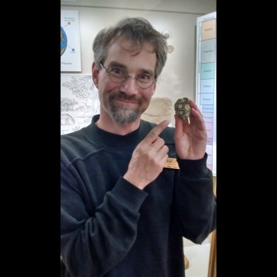 Russell J. Hawley, in his short lived goatee phase, cheerfully holding some fossil coral.
